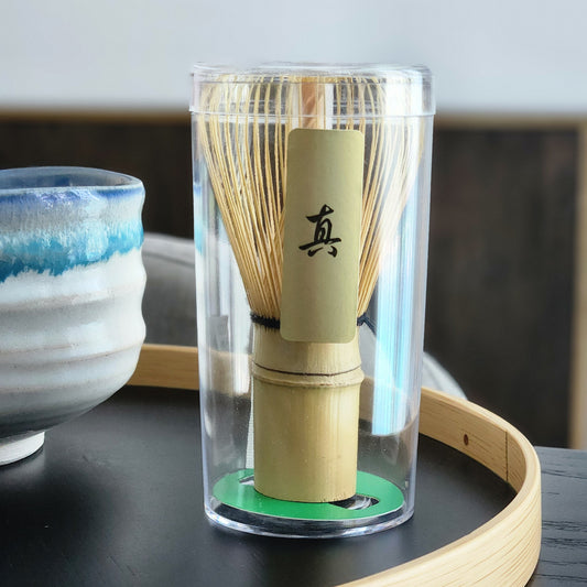Bamboo whisk with transparent holder on a wooden stand